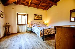 a bedroom with a bed and a wooden floor at Tenuta di Collestretto in Stazzano Nuovo