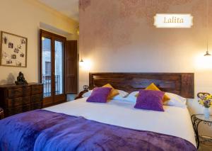 a bedroom with a large bed with purple pillows at Cal Cabré del Priorat - Alojamiento y Bienestar in Pradell +44 photos