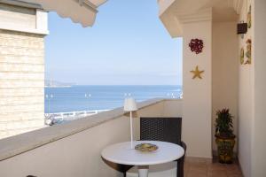a balcony with a table and a view of the ocean at The Square - Luxury Apartment in Scilla