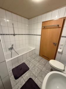a bathroom with a tub and a toilet and a sink at Ferienwohnung Olpe in Olpe