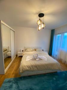a bedroom with a bed with two towels on it at Alpine Grace Retreat in Novaci-Străini