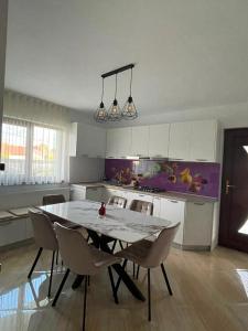 a kitchen with a table and chairs in a room at Alpine Grace Retreat in Novaci-Străini
