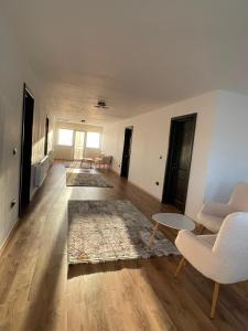 an empty living room with two chairs and a rug at Alpine Grace Retreat in Novaci-Străini