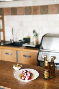 a table with a plate of food and two bottles of beer at Scharioth Birtok in Nagyréde