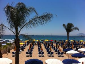 a group of chairs and umbrellas on a beach at Azurene Royal Hotel in Cannes +23 photos