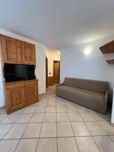 a living room with a couch and a flat screen tv at Alpine Living Apartments in Bormio