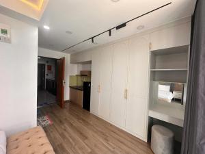 a living room with white cabinets and a kitchen at Căn hộ Na Uy in Nha Trang