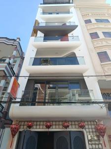 a tall white building with a balcony on it at Căn hộ Na Uy in Nha Trang