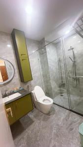 a bathroom with a toilet and a shower and a sink at Căn hộ Na Uy in Nha Trang