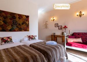 a hotel room with two beds and a couch at Cal Cabré del Priorat - Alojamiento y Bienestar in Pradell