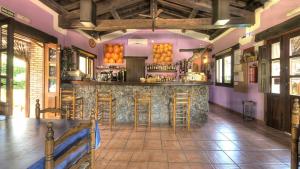 a bar in a restaurant with purple walls and stools at El Canchal de la Gallina - Piscina de agua caliente hasta 15 de octubre in Hervás