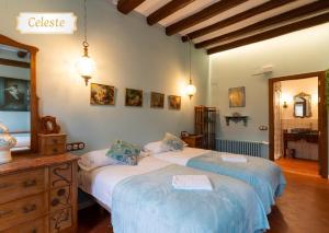 a bedroom with two beds and a mirror at Cal Cabré del Priorat - Alojamiento y Bienestar in Pradell