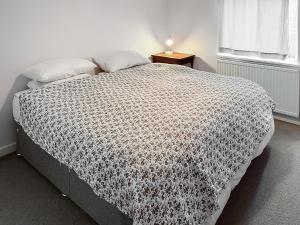a bedroom with a bed with a black and white comforter at The Anchorage in Collieston
