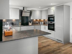 a kitchen with white cabinets and a counter top at The Anchorage in Collieston