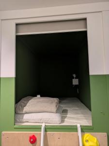 a room with a bed in a green wall at Hostel x Hair ie in Hadano