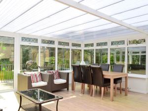 a conservatory with a table and chairs and windows at Burnbeag - Svve in Balloch