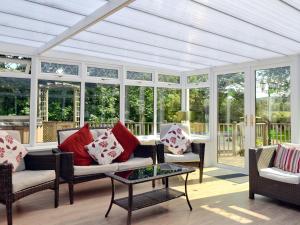 a conservatory with a white ceiling and windows at Burnbeag - Svve in Balloch