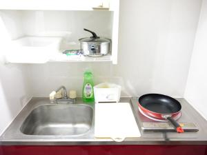 a kitchen counter with a sink and a frying pan at リバーレインアクア in Kagoshima