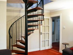 a spiral staircase in a living room at Burnbeag - Svve in Balloch
