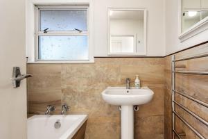 a bathroom with a sink and a window at Beachfront Kiwi bach with direct beach access in Gisborne +28 photos