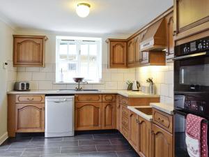 a kitchen with wooden cabinets and a window at Burnbeag - Svve in Balloch