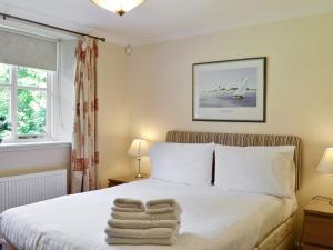 a bedroom with a bed with towels on it at Burnbeag - Svve in Balloch +8 photos