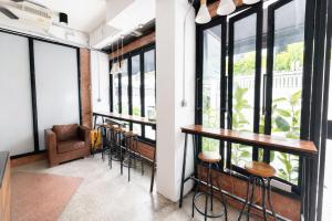 a row of bar stools in a room with windows at Sukhum Ratchada Sutthisan in Bangkok