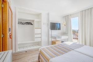 a hotel room with a bed and a balcony at Morlans Garden in Paguera