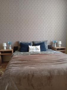 a bedroom with a large bed with blue pillows at Gray in Ternopil