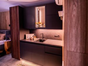 a kitchen with black cabinets and a sink at Metsatiigi Resort in Kersalu