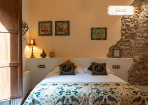 a bedroom with a bed and a stone wall at Cal Cabré del Priorat - Alojamiento y Bienestar in Pradell