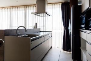 a kitchen with a sink and a stove at VillaMer KAWACHI in Kumamoto