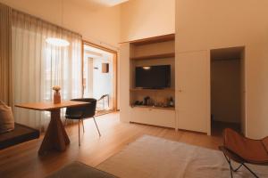 a living room with a dining room table and a television at Casa Caminada in Fürstenaubruck