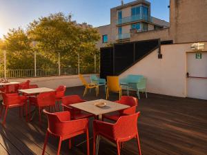 a group of tables and chairs on a deck at BcnSportHostels in Barcelona