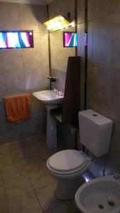 a bathroom with a toilet and a sink at Cabaña La Miranta in Los Reartes