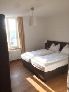 a bedroom with a bed in a room with a window at Alte Post in Bad Griesbach