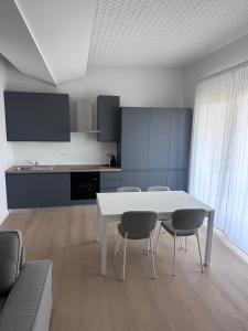 a living room with a white table and chairs at Appartamento Stella - 15' walk to Abano Terme centre in Abano Terme