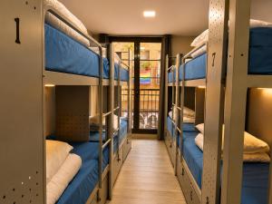 a hallway with several bunk beds in a hostel at BcnSportHostels in Barcelona