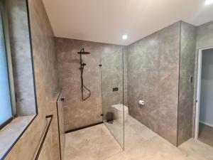 a bathroom with a shower and a toilet at The Breakers - Bunga Street 49 in Bermagui +18 photos