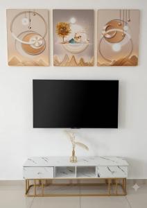 a living room with a flat screen tv on a wall at Golden Paradise Fully Aircond in Kuantan