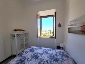 a white room with a bed and a window at Appartamento Losanna in Campo nell'Elba