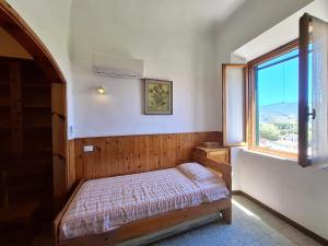 a small bedroom with a bed and a window at Appartamento Losanna in Campo nell'Elba