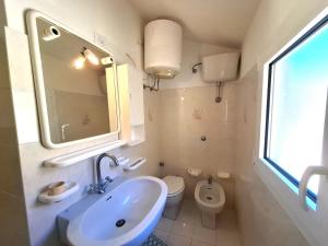 a bathroom with a sink and a toilet at Appartamento Losanna in Campo nell'Elba