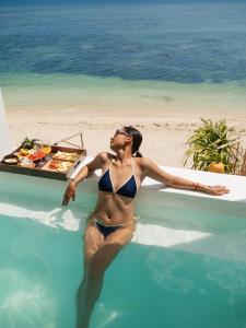 a woman in a bikini in a swimming pool next to the beach at Hani Boutique Hotel Phú Quý in Cù Lao Thu