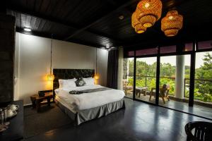 a bedroom with a bed and a large window at Grotta Resort in Gasanze