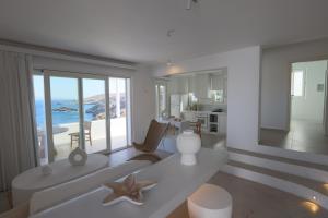 a white living room with a view of the ocean at Three Drops in Kanala