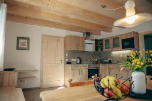 a kitchen with wooden cabinets and a bowl of fruit on a table at Ferienhaus Allmunzen in Witzmannsberg