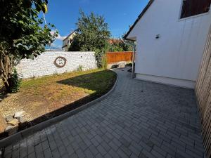a brick driveway next to a white building at Rybářská 32 in Uherské Hradiště