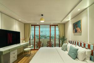 a bedroom with a bed and a desk and a television at Elm Riverside Hotel by Urban B in Ho Chi Minh City
