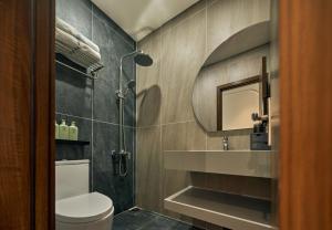 a bathroom with a shower and a toilet and a sink at Elm Riverside Hotel by Urban B in Ho Chi Minh City +79 photos